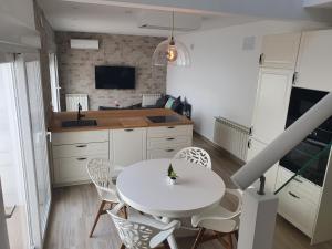 a kitchen with a white table and chairs at Burbujas Manchegas in El Toboso