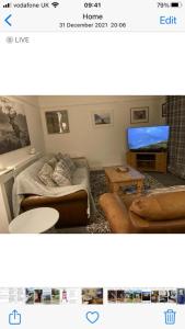 sala de estar con sofá y TV en 9 Afton Barns, en Freshwater