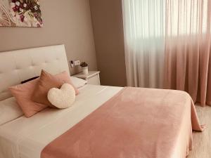 ベニドルムにあるResidencial Cumbre Loix Apartamentosのベッドルーム(ハートピロー付きの白いベッド付)