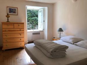 a bedroom with a bed and a dresser and a window at Les Volets Verts in Miraval-Cabardès