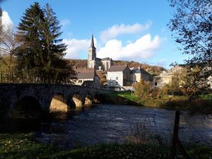 eine Brücke über einen Fluss in einer Stadt mit einer Kirche in der Unterkunft O'Noire, Viroinval Treignes in Treignes
