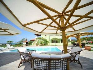 a patio with an umbrella and a swimming pool at Lovely apartment with swimming pool in Ljubač