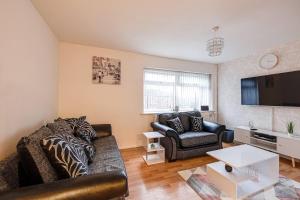 a living room with a couch and a tv at Lovely 2 Bedroom Apartment with fireplace in Manchester