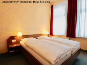 a bedroom with a large bed with a red window at Haus Seeblick in Norderney
