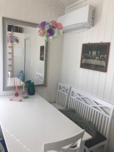 una sala da pranzo con tavolo bianco e specchio di Lyseren waterfront cabin a Omberg