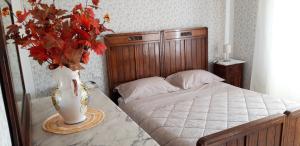1 dormitorio con 1 cama con un jarrón de flores sobre una mesa en Affittacamere La Foresta di Sopra, en Barga