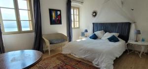 a bedroom with a large bed and a table at Casa ANNA in Calvi