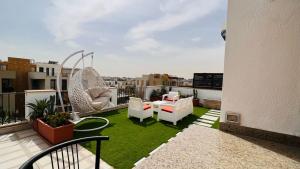 a balcony with chairs and a yard with grass at Sodic Westown Residence 2 in 6th Of October