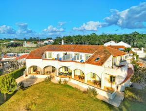 uma vista aérea de uma grande casa branca em Quinta Do Moinho De Vento - Racket & Country Club - Duna Parque Group em Vila Nova de Milfontes