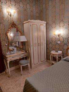 a bedroom with a dresser and a desk with a mirror at Residenza Hotel San Maurizio in Venice