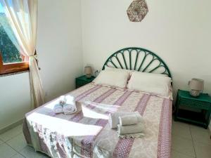1 dormitorio con 1 cama con manta y toallas en Casa Giada Costa Rei, en Costa Rei