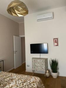 1 dormitorio con 1 cama y TV en la pared en La Casa di Bea, en Piombino