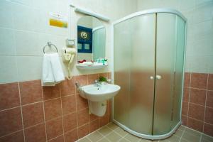 ein Bad mit einer Dusche und einem Waschbecken in der Unterkunft La Villa Palace Hotel in Doha