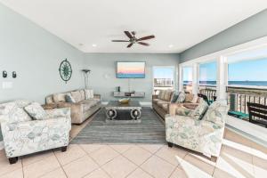 a living room with two couches and a flat screen tv at Grotto on the Gulf in Fort Morgan +62 photos