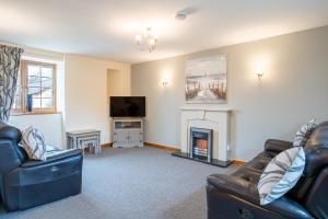 sala de estar con 2 sofás y chimenea en Yr Wyddfa Cottage Anglesey, en Llanfairpwllgwyngyll