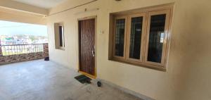an empty room with a door and a balcony at TG TOWERS SERVICE Apartments Homestay in Vijayawāda