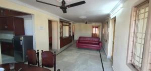 a living room with a red couch and a ceiling fan at TG TOWERS SERVICE Apartments Homestay in Vijayawāda