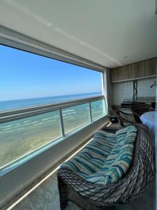 um quarto com uma cama e uma grande janela em Mongaguá com vista para o Mar pé na areia em Mongaguá