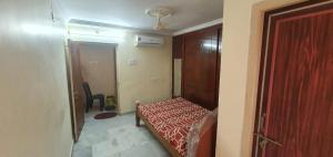 a small bedroom with a bed and a door at TG TOWERS SERVICE Apartments Homestay in Vijayawāda