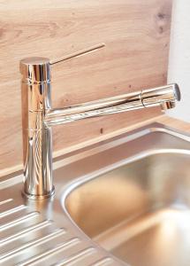 a stainless steel kitchen sink with a silver faucet at Ferienwohnung - Appartment Breivogel in Wörrstadt in Wörrstadt