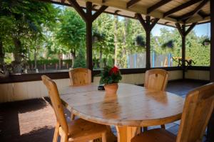 a wooden table with chairs and a potted plant on it at Villa Magonīte in Ventspils