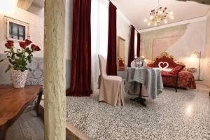 a living room with a table and red curtains at Locanda Casa Martini in Venice