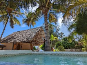 a resort with a palm tree and a swimming pool at Moonshine Uroa Boutique Hotel in Uroa