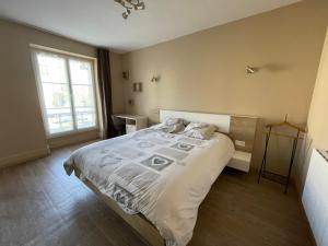 ein Schlafzimmer mit einem Bett und einem großen Fenster in der Unterkunft Appartement 42 m2 à Vittel proche Thermes-SPA in Vittel