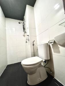 a white bathroom with a toilet and a sink at Comfy Studio Vista Alam in Shah Alam