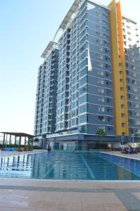 een groot gebouw met een zwembad ervoor bij Comfy Studio Vista Alam in Shah Alam