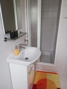 uma casa de banho branca com um lavatório e um chuveiro em Ferienwohnung Tensfeldt em Lübben