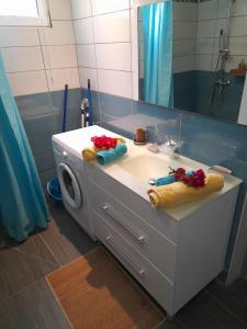 un bagno con lavandino e specchio di Janelle a Le Diamant
