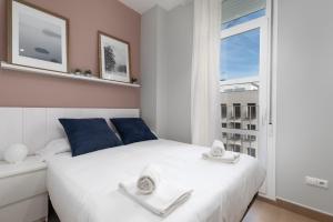 Un dormitorio con una cama blanca y una ventana. en Adarve Flats, en Valencia