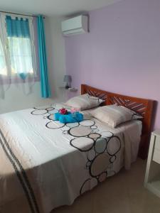 una camera da letto con un letto decorato con fiori di Janelle a Le Diamant
