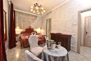 sypialnia z łóżkiem, stołem i krzesłami w obiekcie Locanda Casa Martini w Wenecji