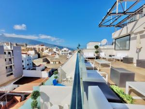 uma vista do telhado de um edifício com mesas e cadeiras em Puerto Azul em Puerto de la Cruz