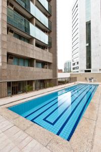 a swimming pool in a building with a blue sky at Promenade Pancetti Belo Horizonte in Belo Horizonte