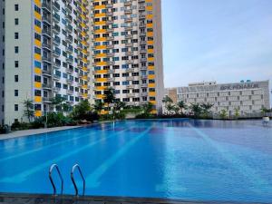 RawabugelThe City Sky Studio MDNPRO APT Springlake SMB的两栋建筑中间的一个大型游泳池