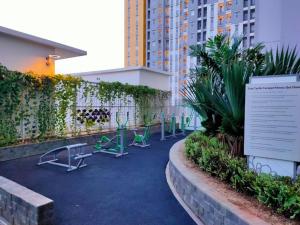 RawabugelThe City Sky Studio MDNPRO APT Springlake SMB的一座建筑前的庭院,配有椅子和标志