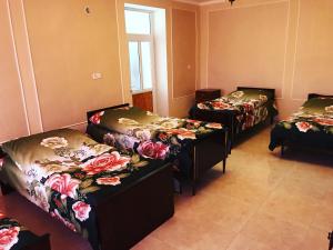 pokój z 3 łóżkami z kwiatami w obiekcie Hayq Guest House w mieście Goris