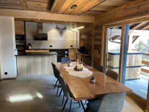 莫爾濟訥的住宿－CHALET MITCH，厨房以及带木桌和椅子的用餐室。