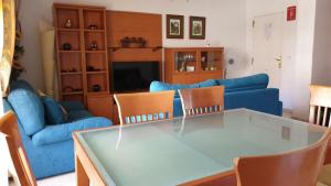 een woonkamer met een tafel en een blauwe bank bij Cascadas De Las Marinas in Denia