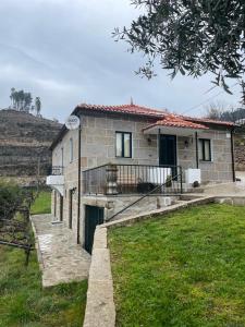 uma casa de pedra com um portão em frente em Quintinha de Pinouco em Resende