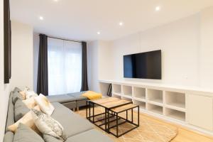 a living room with a couch and a tv at New Guggenheim in Bilbao