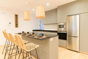 a kitchen with a counter with chairs and a refrigerator at New Guggenheim in Bilbao