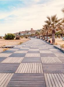 a boardwalk with palm trees on a beach at Casa Serra in Porto Palo