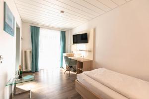 a hotel room with a bed and a desk at Hotel Christine in Radolfzell am Bodensee