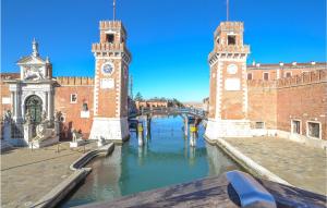 a river with two clock towers next to a building at Beautiful apartment in Venezia with WiFi in Venice