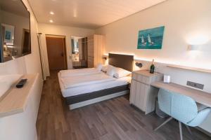 a hotel room with a bed and a desk at Hotel Christine in Radolfzell am Bodensee