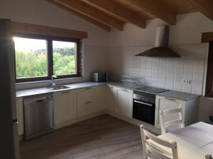 a kitchen with a sink and a stove and a window at Casa Mestres in Pujalt